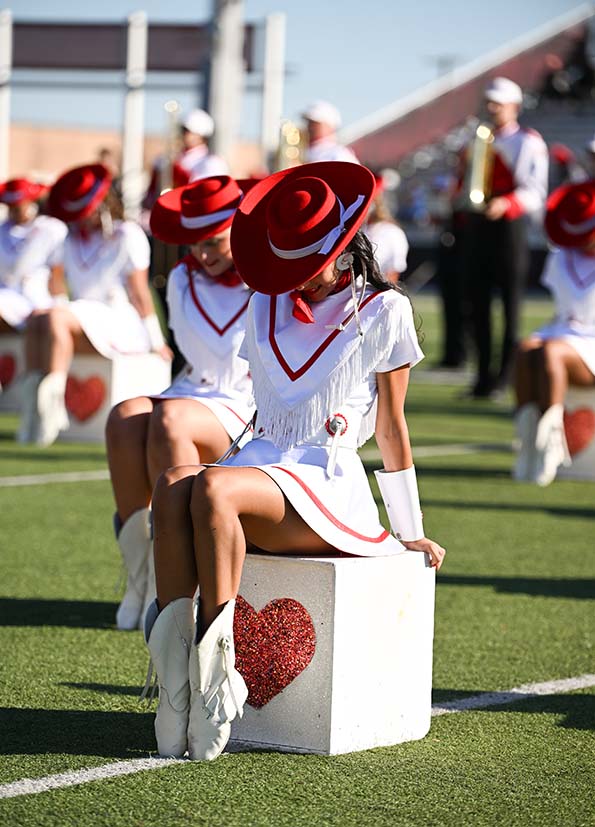 cardettes on football field sitting on boxes and posing